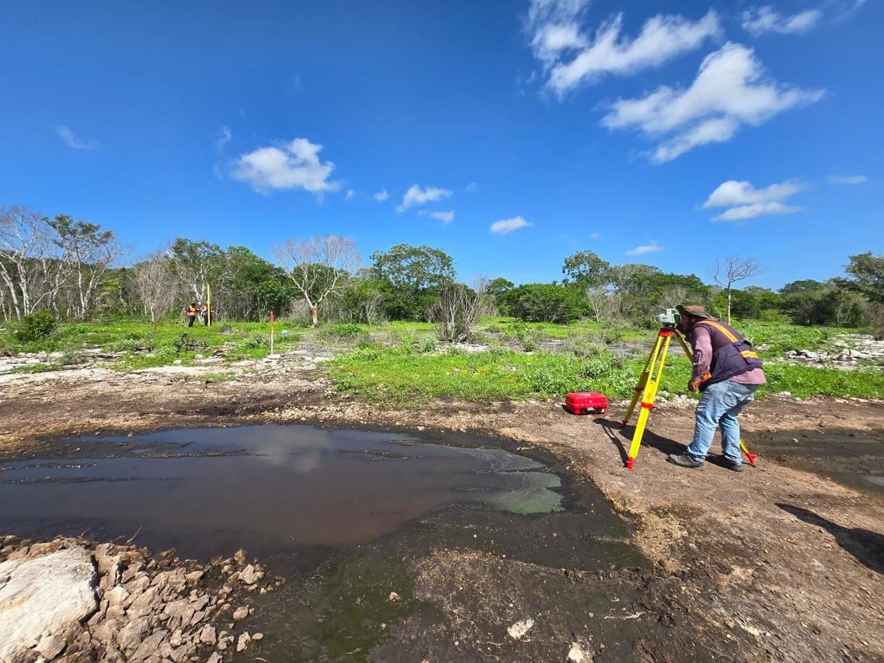 Topógrafa levantando una zona de escurrimiento